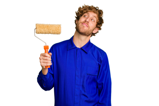 Young painter man holding a roll isolated on white background dreaming of achieving goals and purposes