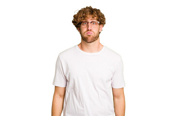 Obraz premium Young caucasian man isolated on green chroma background blows cheeks, has tired expression. Facial expression concept.