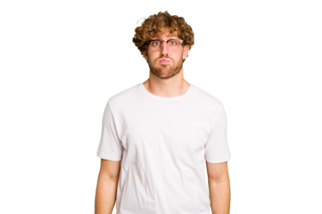 Young caucasian man isolated on green chroma background blows cheeks, has tired expression. Facial expression concept.
