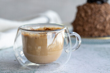 Coffee mug on gray background. Coffee with cake in the background. close up
