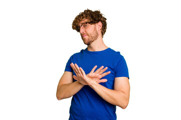 Young caucasian man isolated on green chroma background doing a denial gesture