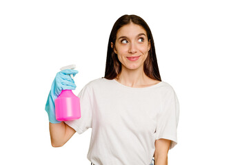 Young cleaner woman isolated dreaming of achieving goals and purposes