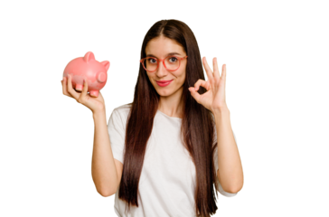 Young caucasian woman holding a piggy bank isolated cheerful and confident showing ok gesture.