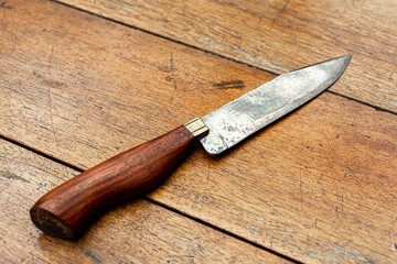 Vintage BBQ knife with rustic wooden handle on aged wooden table