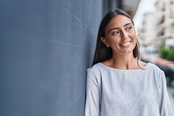 Young beautiful hispanic woman smiling confident looking to the side at street