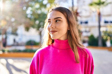 Young woman smiling confident looking to the side at park