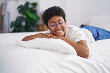 Fototapeta na wymiar African american woman smiling confident lying on bed at bedroom