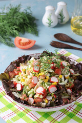 Cabbage salad with crab sticks, tomatoes and corn served on lettuce leaves