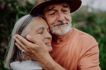 Portrait of senior couple in love, standing and hugging outdoor in nature.