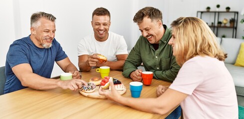 Group of middle age friends having breakfast sitting on the table at home.