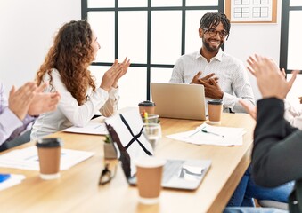 Group of business workers smiling and clapping to partner at the office.