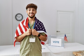 Young arab man smiling confident wearing united states flag at electoral college