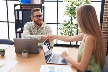Man and woman business workers shake hands working at office