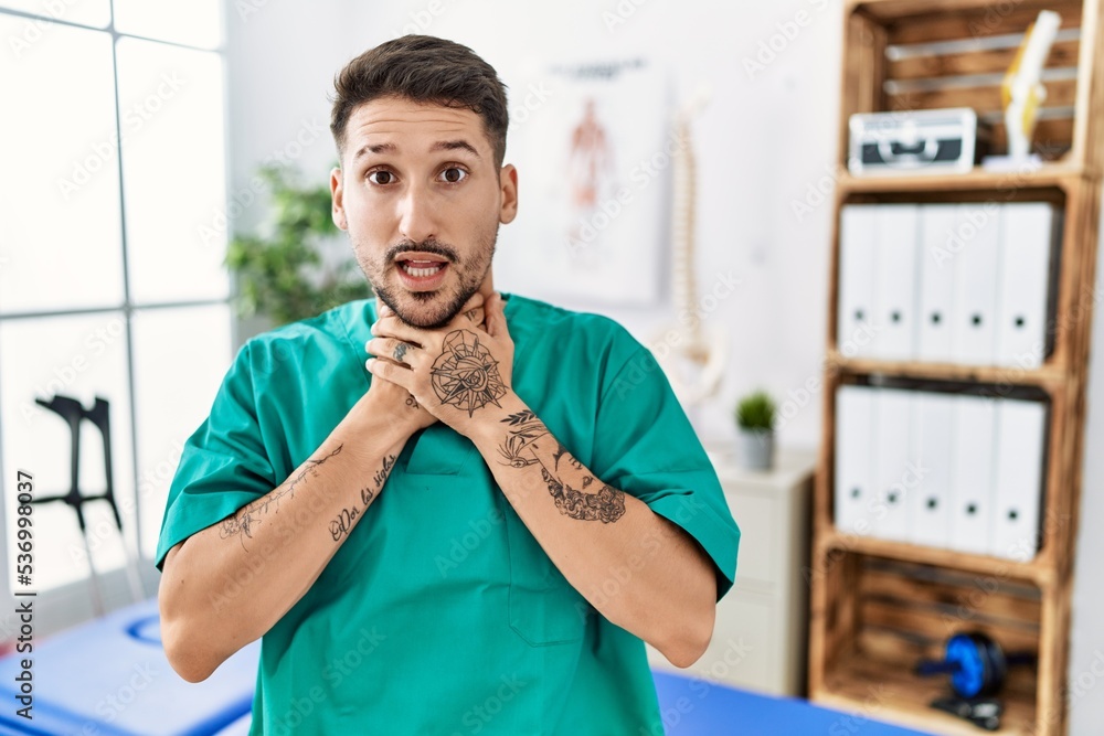 Wall mural Young physiotherapist man working at pain recovery clinic shouting suffocate because painful strangle. health problem. asphyxiate and suicide concept.