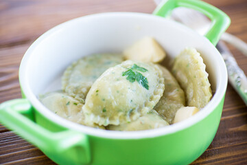 Boiled dumplings with stuffing inside, from dough with herbs