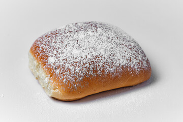 bun with powdered sugar on white background