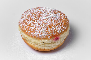 round bun with fruit cream with powdered sugar on a white background