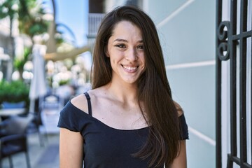 Young hispanic girl smiling happy standing at the city.