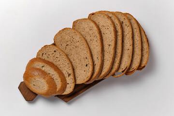 sliced loaf of black bread on a kitchen board on a white background