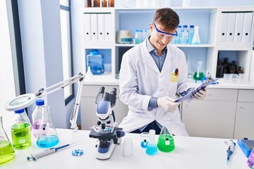 Young man using smartphone sitting on sofa at laboratory