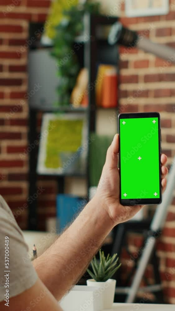 Poster vertical video: office worker analyzing smartphone with greenscreen template, using isolated display