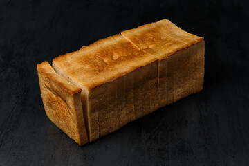 square loaf of white bread on black background, close view