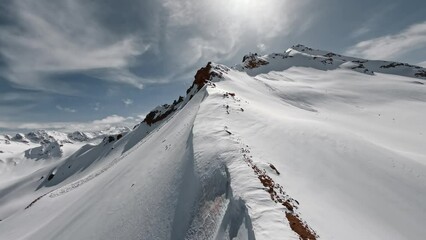 Aerial view flying over picturesque mountain ridge snowy rock texture sun light blue sky landscape. FPV sports drone empty alpine scenery winter glacier freeze valley natural cliff range freeze summit - Powered by Adobe