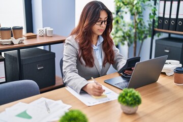 Young hispanic woman business smiling confident working at office