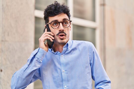 Young caucasian man talking on the smartphone with serious expression at street