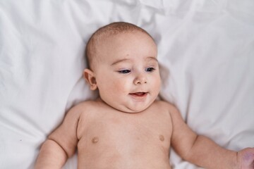 Adorable baby smiling confident lying on bed at bedroom