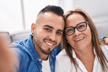 Man and woman mother and son make selfie by smartphone at home