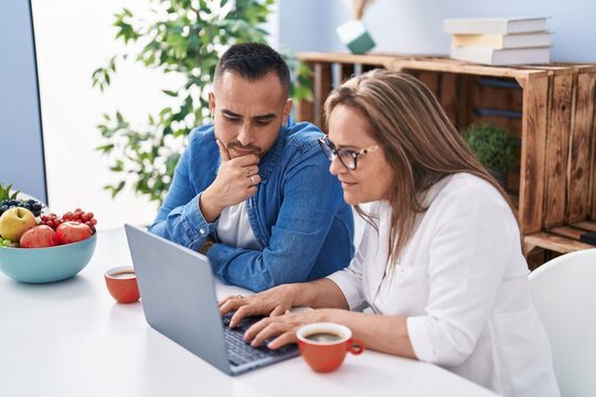 Man And Woman Mother And Son Drinking Coffee Using Laptop At Home