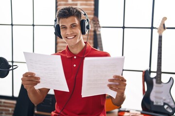 Young hispanic man musician singing song at music studio