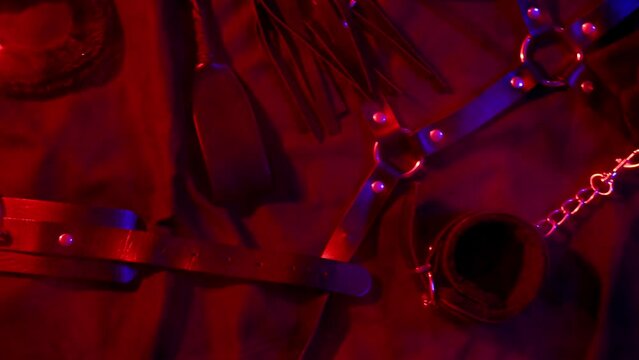 Handcuffs, leather whip flogger, mask and choker for BDSM sex with submission and domination. Concept of erotic adult sex toys
