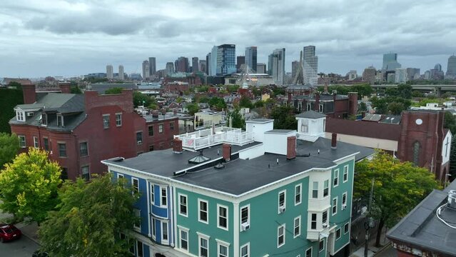 Colorful homes in Charlestown neighborhood. Aerial reveals downtown Boston Skyline and Bunker Hill Bridge.