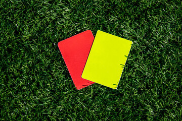 Referee soccer, football game, red and yellow cards on green grass. Two penalty cards for the...