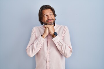 Handsome middle age man wearing elegant shirt background laughing nervous and excited with hands on...