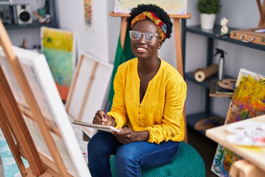 Young african american woman artist smiling confident drawing at art studio