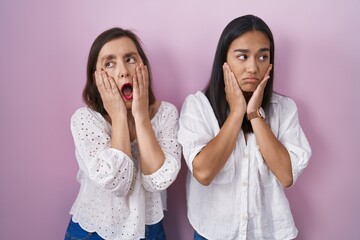 Hispanic mother and daughter together tired hands covering face, depression and sadness, upset and irritated for problem