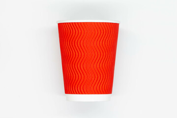 Paper coffee cup. Red craft paper coffee cup without lid. Disposable cup for safe drinking of hot and cold drinks. Safe ribbed capacity. Container for healthy beverage. Isolated. Close-up