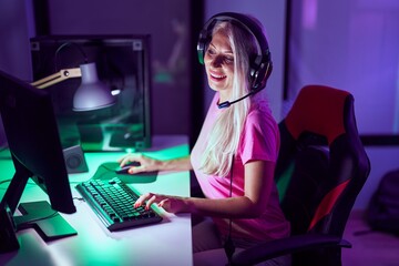 Young blonde woman streamer smiling confident using computer at gaming room