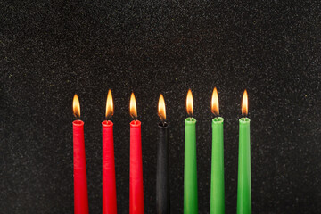 Kwanzaa festival concept with seven candles red, black and green on black background, copy space