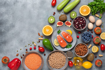 Healthy balanced food. Salmon, cereals, fruits, vegetables, seeds. Clean organic food. Top view, flat lay, copy space. Gray concrete background.