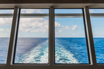 Blick durch das Heckfenster eines Kreuzfahrtschiffs