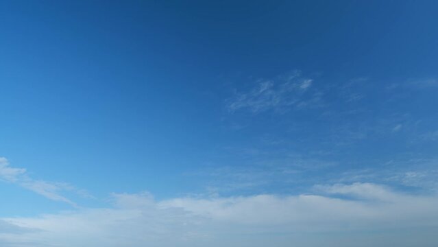 Summer blue sky with fluffy white clouds. White clouds float across the blue sky. Timelapse.