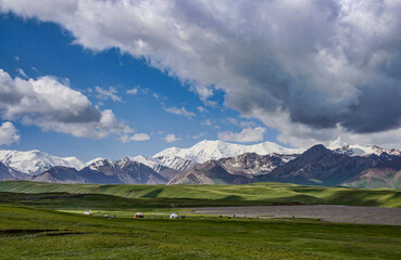The High Pamirs rise over a lone yurt along the Pamir Highway, Kyrgyzstan