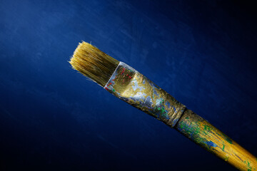 Single artist paint brush on a blue textured background fine art