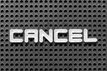 White alphabet letter in word cancel on black pegboard background