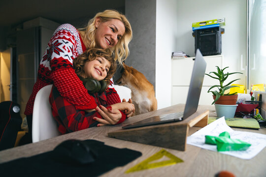 Mother And A Son Having A Video Call With A Long Distance Family Member Using Laptop