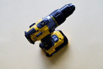 Yellow battery powered drill on color background